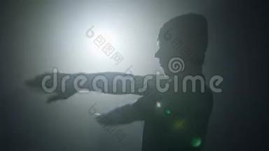 一位才华横溢的年轻舞者在聚光灯前的舞台上跳嘻哈街舞的剪影